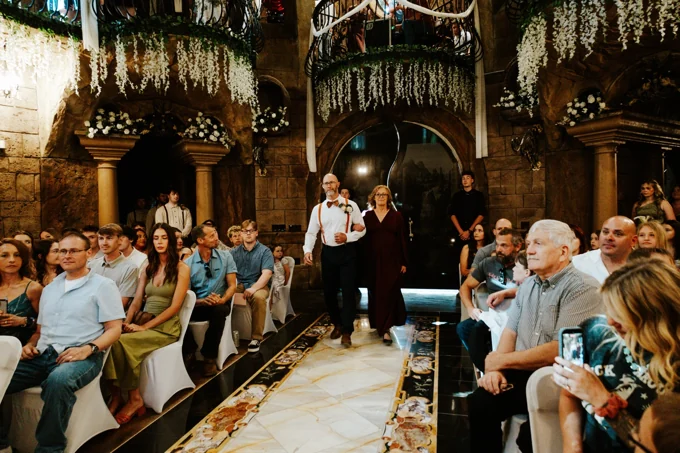 Guests watching a pair walk down the aisle beneath the chapel balconies