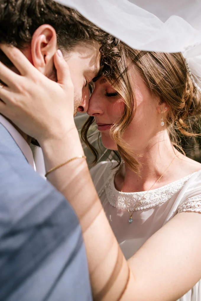 Couple sharing a quiet moment beneath a wedding veil